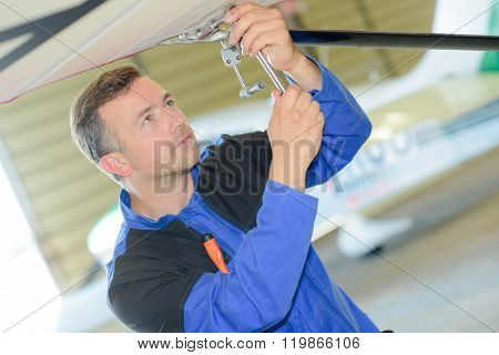 Man working on the underside of an aircraft