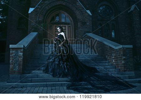 Mysterious woman in black dress near chirch
