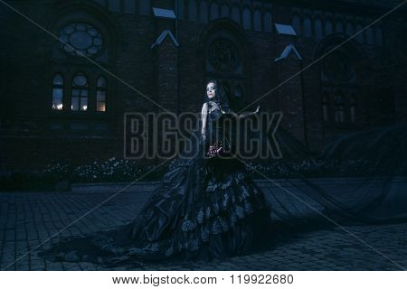 Mysterious woman in black dress near chirch