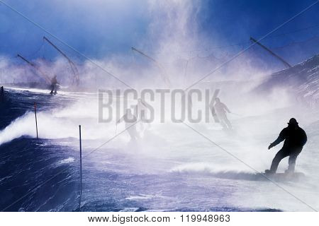 Silhouettes of skiers going down the mountain