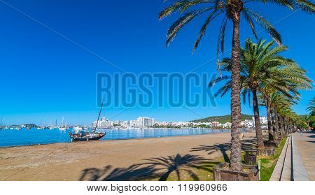 Abandoned sail boat on the beach.  Mid morning sun on Ibiza waterfront.