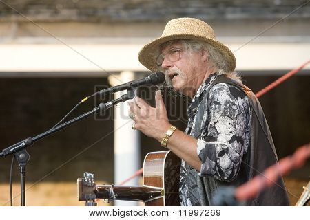 Nowy Jork - 30 lipca: Muzyk Arlo Guthrie gestów, jak on wykonuje w parku Battery Castle Clinton o