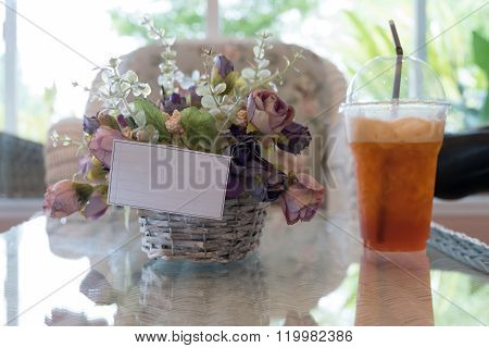 White Paper Blank On Flowers Vase Decorated In Cafe