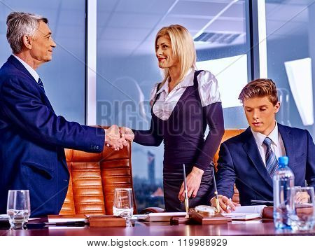 Happy business people in luxury office. Man handshake woman.