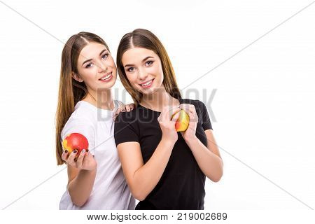 portrait of smiling twins with apples in hands looking at camera isolated on white