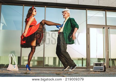 Retired and a young woman dancing fast dance on the street.