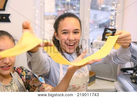 Moscow Russia December 16 2017: Unidentified teenager girl cooking pasta on culinary master class event party signifying final days of stydiyng period in Moscow Russia December 162017