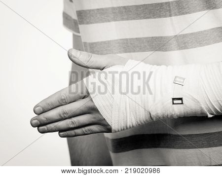 Fractures and dislocations concept. Part body male with hand in bandage. Helpful medication for painful palm arm of young man.
