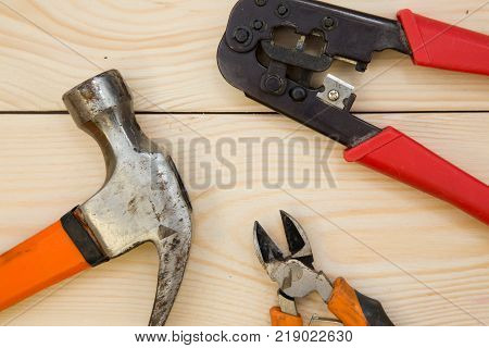 Repairing a house. A set of repair tools- a hammer and pilers on a light uncolored wooden background. Close up. Top view. Space for your text or pruduct display.