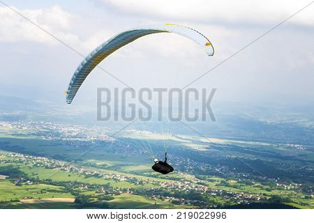 Paraglider flying over the fields on a sunny day. Poland.