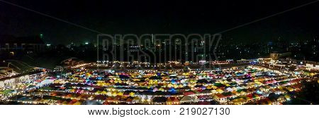 panorama landscape view colorful of plastic roof of tent at ratchada train night market with dark sky of bangkok city. popular place for shopping at night.