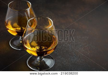 Glass of brandy or cognac on the old rusty background