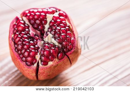 Big red pomegranate on the wooden board. Ripe granet fruit.