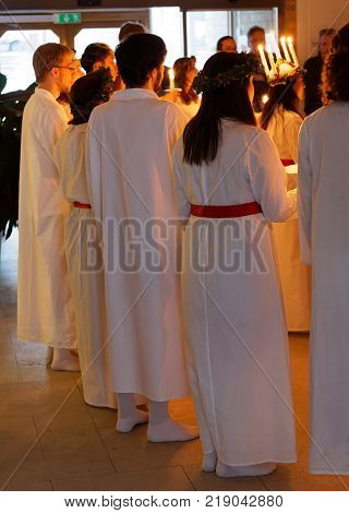STOCKHOLM SWEDEN - DEC 13 2017: Lucia parade with singing girls and boys in white dresses holding candles. Traditional celebration of the suffering of saint Lucia from Italy in Stockholm Sweden December 13 2017