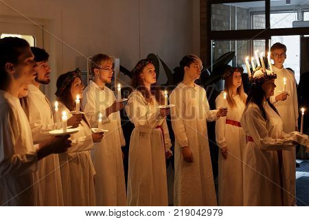 STOCKHOLM SWEDEN - DEC 13 2017: Lucia parade with singing girls and boys in white dresses holding candles. Traditional celebration of the suffering of saint Lucia from Italy in Stockholm Sweden December 13 2017