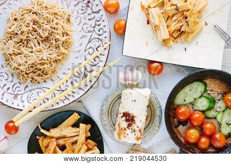 Top view of asian table with chinese noodles, roasted paneer or tofu and vegetables