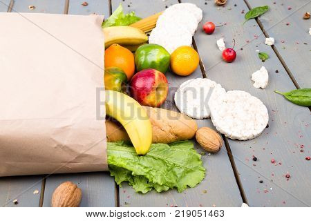 Grocery Shopping Concept. Different Food In Paper Bag On Wooden Background.  Flat Lay.