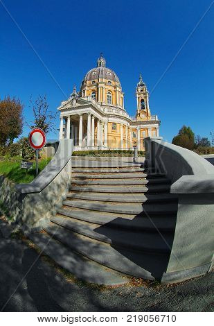 Vertical view on beautiful white orange church Superga in italian Alps mountains. Italian Superga cathedral church. Italian antique baroque architecture. Italy church