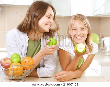 Happy Mother with Daughter eating Healthy food. Diet. Healthy Eating Concept