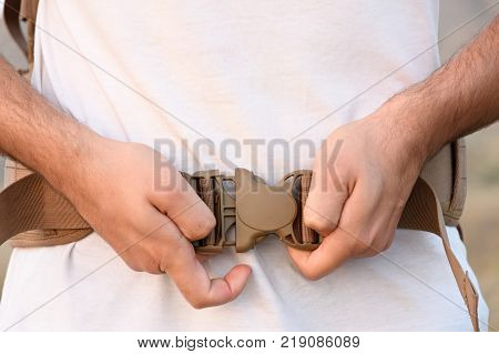 A Young Man Demonstrates Fastex Buckle In Action From The Waist Belt Of A Backpack