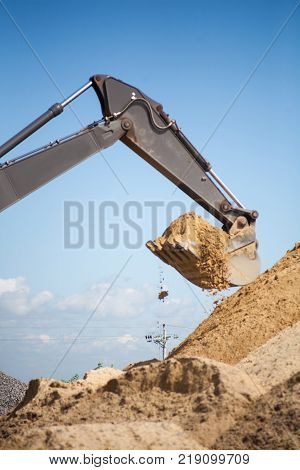 A large construction excavator of yellow color on the construction site in a quarry for quarrying