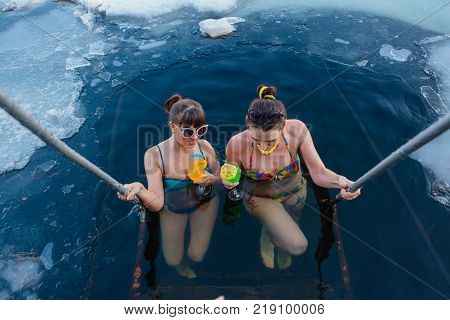 Novokuznetsk, Kemerovo region, Russia - 23 Feb, 2017 : White beaches of Siberia is an enterteiment activity where people playing beach games dressed in bikini in winter. Women in ice hole with drinks