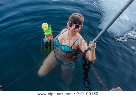 Novokuznetsk, Kemerovo region, Russia - 23 Feb, 2017 : White beaches of Siberia is an enterteiment activity where people playing beach games dressed in bikini in winter. Woman in an ice hole