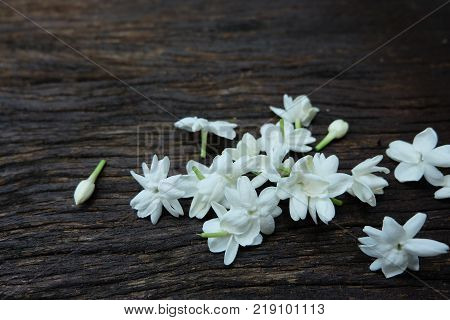 White jasmine flowers on old wooden plate.