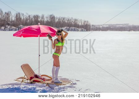 Novokuznetsk, Kemerovo region, Russia - 23 Feb, 2017 : White beaches of Siberia is an enterteiment activity where people playing beach games dressed in bikini in winter. Woman in bikini with pineapple