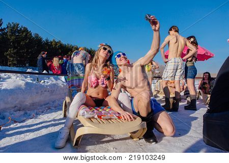 Novokuznetsk, Kemerovo region, Russia - 23 Feb, 2017 : White beaches of Siberia is an enterteiment activity where people playing beach games dressed in bikini in winter. Woman in bikini and a man