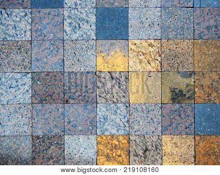 Checked pattern of various kinds of natural stone. A fragment of faced wall. Squares of grey, blue and gold for natural background.