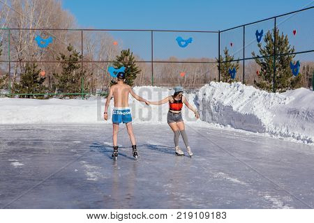 Novokuznetsk, Kemerovo region, Russia - 23 Feb, 2017 : White beaches of Siberia is an enterteiment activity where people playing beach games dressed in bikini in winter. Couple in shorts on ice skates