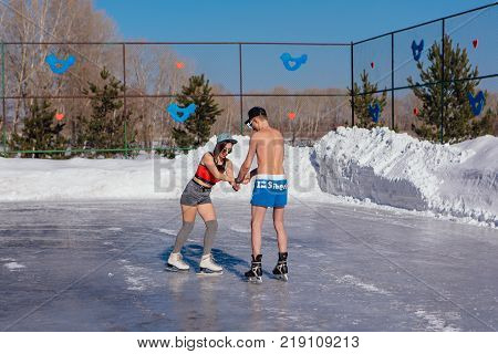Novokuznetsk, Kemerovo region, Russia - 23 Feb, 2017 : White beaches of Siberia is an enterteiment activity where people playing beach games dressed in bikini in winter. Couple in shorts on ice skates