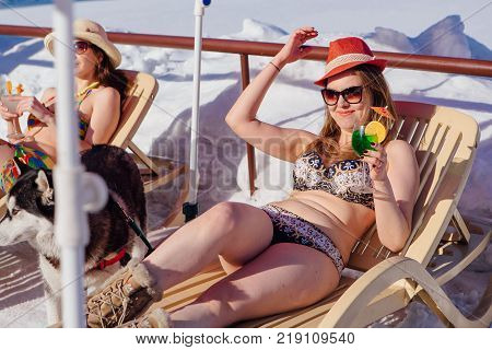 Novokuznetsk, Kemerovo region, Russia - 23 Feb, 2017 : White beaches of Siberia is an enterteiment activity where people playing beach games dressed in bikini in winter. Woman in bikini with cocktail