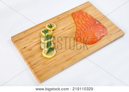 Smoked Fillet trout with lemon on a cutting board. Seafood.