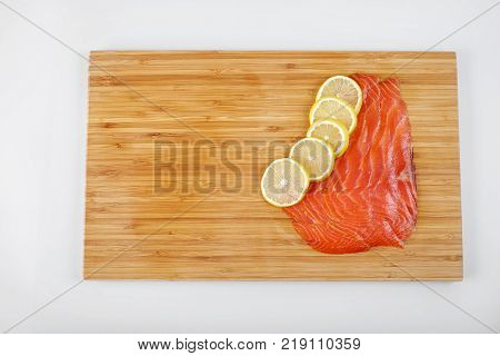 Smoked Fillet salmon with lemon on a board. Seafood.