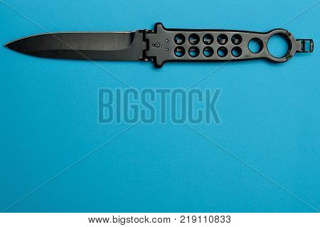Steel butterfly knife (balisong) isolated on a blue background