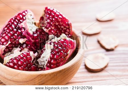 Big red pomegranate on the wooden board. Ripe granet fruit. Broken pomegranate.