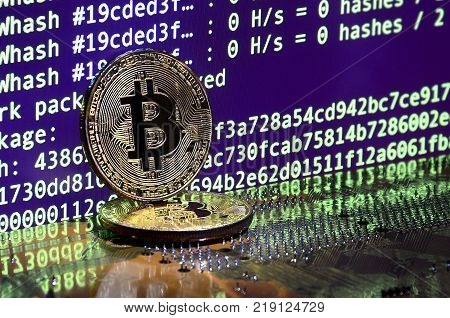 The digital process of cryptocurrency mining by using the GPUs. Bitcoins and video card on a working display and mining screen