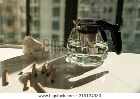 tea pot with measure tape and pencil on the working table working and rest concept