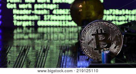 The digital process of cryptocurrency mining by using the GPUs. Bitcoins and video card on a working display and mining screen
