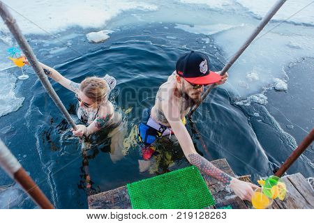 Novokuznetsk, Kemerovo region, Russia - 23 Feb, 2017 : White beaches of Siberia is an enterteiment activity where people playing beach games dressed in bikini in winter. Couple in ice hole