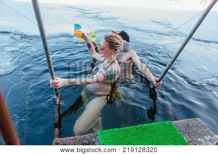 Novokuznetsk, Kemerovo region, Russia - 23 Feb, 2017 : White beaches of Siberia is an enterteiment activity where people playing beach games dressed in bikini in winter. Couple in ice hole