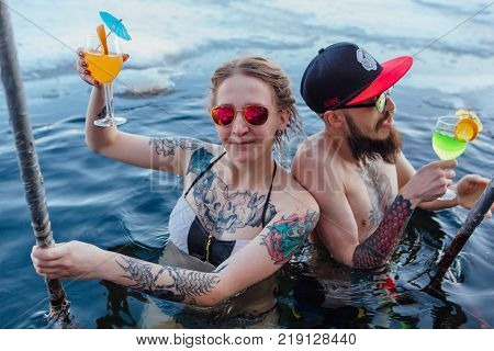 Novokuznetsk, Kemerovo region, Russia - 23 Feb, 2017 : White beaches of Siberia is an enterteiment activity where people playing beach games dressed in bikini in winter. Couple in ice hole
