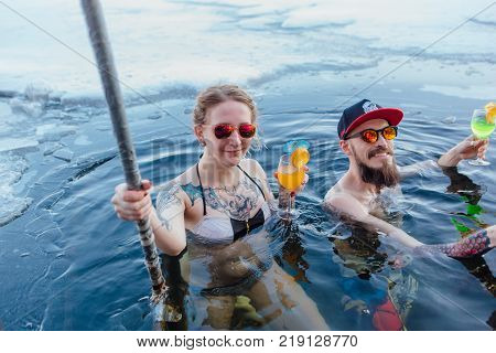 Novokuznetsk, Kemerovo region, Russia - 23 Feb, 2017 : White beaches of Siberia is an enterteiment activity where people playing beach games dressed in bikini in winter. Couple in ice hole