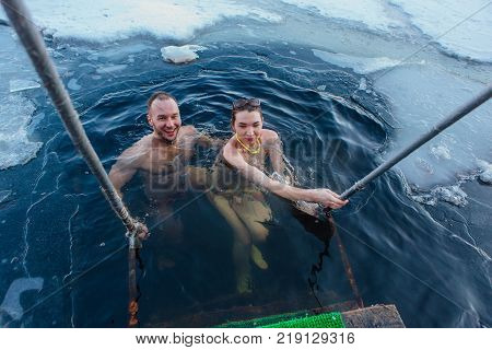 Novokuznetsk, Kemerovo region, Russia - 23 Feb, 2017 : White beaches of Siberia is an enterteiment activity where people playing beach games dressed in bikini in winter. Couple in ice hole