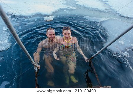 Novokuznetsk, Kemerovo region, Russia - 23 Feb, 2017 : White beaches of Siberia is an enterteiment activity where people playing beach games dressed in bikini in winter. Couple in ice hole