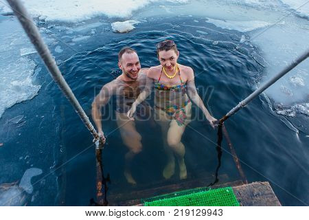 Novokuznetsk, Kemerovo region, Russia - 23 Feb, 2017 : White beaches of Siberia is an enterteiment activity where people playing beach games dressed in bikini in winter. Couple in ice hole