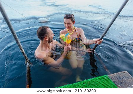 Novokuznetsk, Kemerovo region, Russia - 23 Feb, 2017 : White beaches of Siberia is an enterteiment activity where people playing beach games dressed in bikini in winter. Couple in ice hole