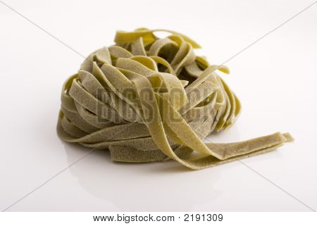 Tagliatelle italiano con espinaca sobre fondo blanco